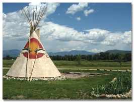 Aerial view of the teepee at the center of Eagle Soaring RV Park surrounded by lawn and the camp loop road