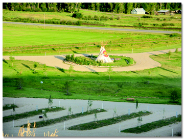 Traditional teepee centerpiece at Eagle Soaring RV Park with open meadow and mountains behind it